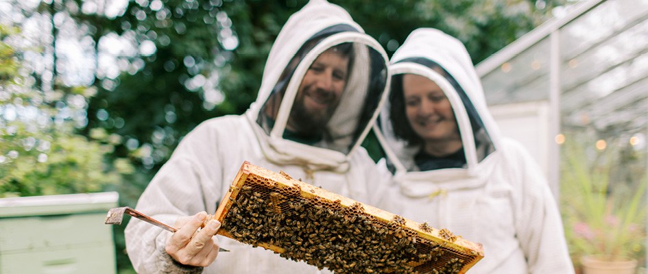 Amy-Beth and her husband, Peter, in beekeeping gear - Photo by Holly Cuaresma