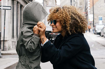 mother and child holding hands on rainy day