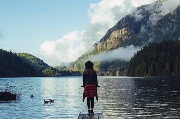 standing on mountain lake pier
