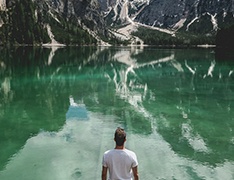 A person standing in front of a mountain lake