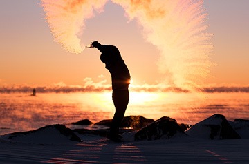 person tossing sand on the beach