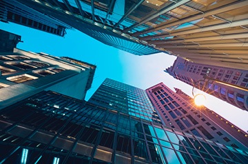 Looking skyward surrounded by glass-sided skyscapers