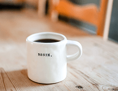 coffee mug reading 'BEGIN.'