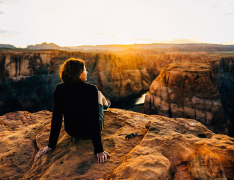 hiker sitting atop Grand Canyon