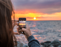 person taking photo of sunset