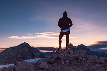 hiker viewing sunset over mountains