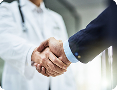doctor shaking hands with businessperson