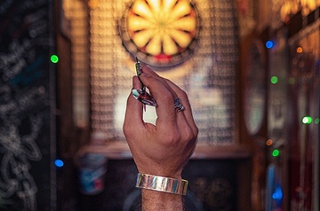 aiming dart at dartboard