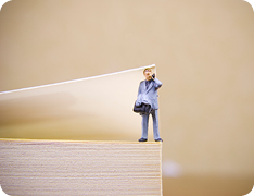 closeup of book cover propped open with a miniature toy businessman