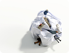 Toy businesspeople in crumpled piece of paper