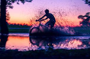 person riding bike through shallow water