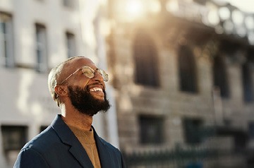 Man with glasses and beard looking at the sky