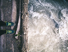 An overhead view of someone standing on cliffs over an ocean