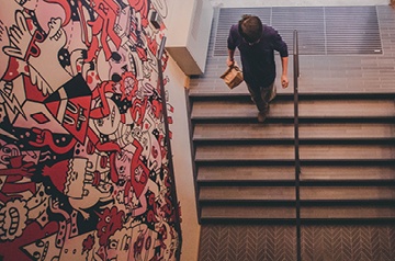 walking down steps, murals on wall