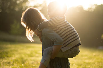 mom giving kid piggy back ride