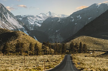 countryside road, snowy mountains behind