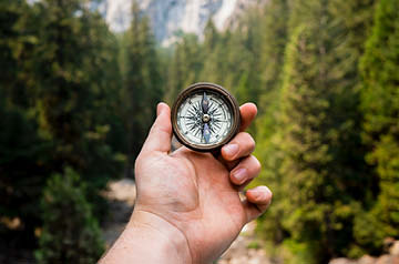 holding up compass in woods