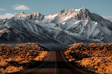 high desert highway leading to snowy mountains
