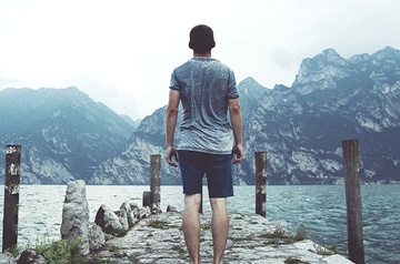 standing lakeside, mountains behind
