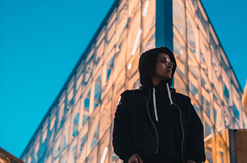 standing in front of brightly lit building at dusk