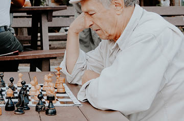 leaning over chessboard