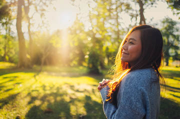 Smiling woman in a sunny glade