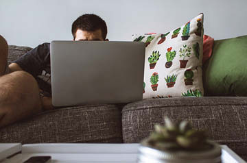 person using laptop on couch