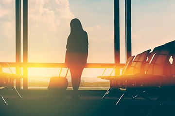 waiting in airport terminal, sunset behind