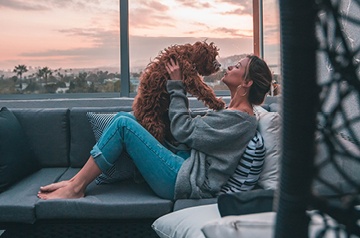kissing pet dog on couch