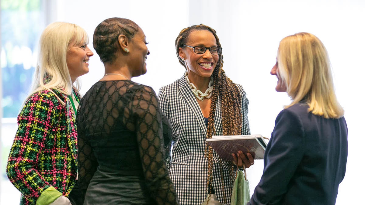 Jamie Pennington, Scharrel Jackson, Dr. Kelly Elmore, Stacy: Four women standing in a circle smiling and chatting.