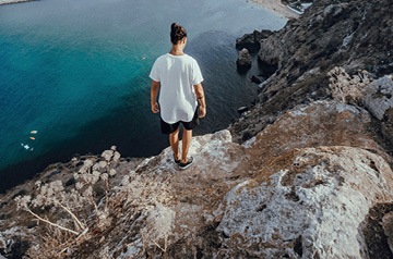 standing at cliff's edge, ocean below