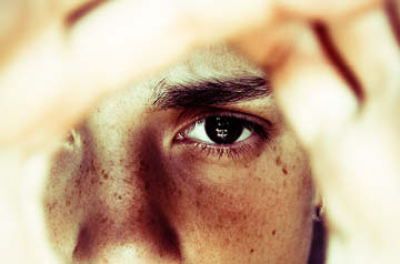 eye looking through viewfinder hands