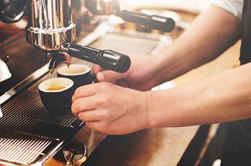 barista making two shots of espresso