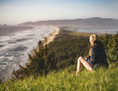 person viewing coastline from grassy hill