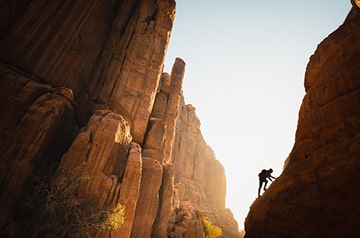 Man hiking distant canyon mountains