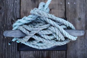 closeup of knots holding boat to pier