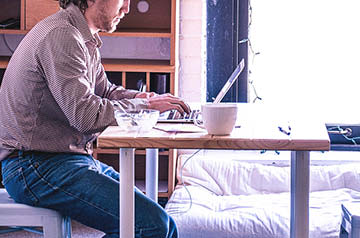 person sitting at desk in apartment bedroom