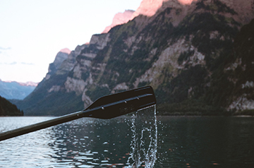 An oar coming out of the water on a mountain lake