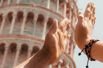 high five in front of Tower of Pisa