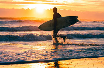 surfer running toward waves