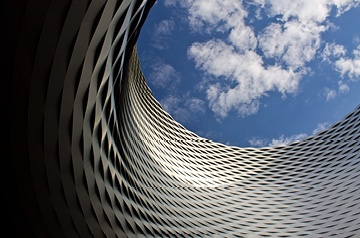 Looking skyward along curved side of skyscraper