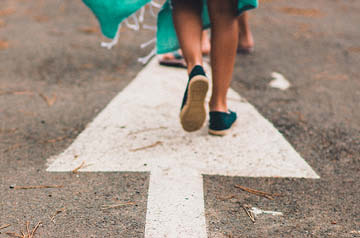 people walking on painted arrow