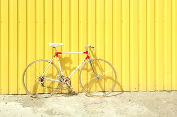 bicycle leaning on yellow wall