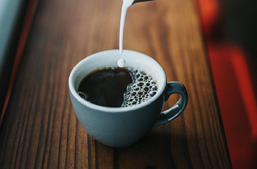 pouring creamer in coffee