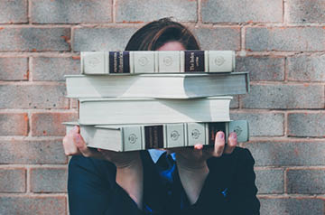 holding stack of books