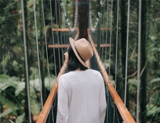 woman walking over suspended pedestrian bridge