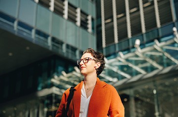 Woman standing outside a high-rise building.