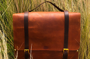 A satchel in front of tall grass