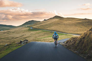person cycling on winding road