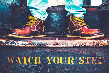 boots on staircase that reads 'watch your step'